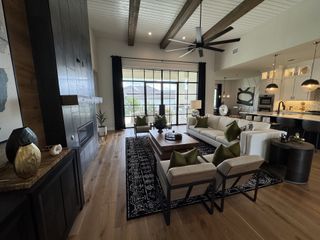 A spacious living area with wooden beams, modern furniture, and a large window view, blending luxury and comfort.