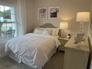 Model Home A cozy bedroom featuring a plush bed, elegant artwork, and soft lighting creating a warm, inviting atmosphere.