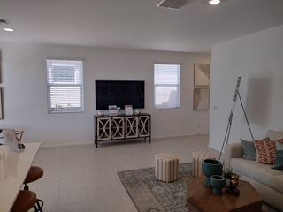 A cozy living room with a large TV, patterned rug, and modern decor creating a welcoming ambiance.