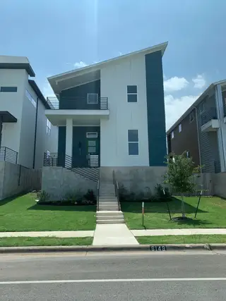 A modern two-story home with a unique roofline and manicured lawn in Agave by InTown Homes (Austin, TX).