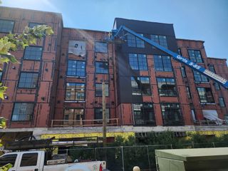 A side view of the ongoing construction at Congress Lofts Saint Elmo, showcasing the facade and scaffolding. A work in progress by Intracorp (Austin, TX).
