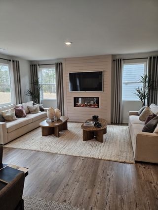 Model Home A sophisticated living room with a built-in fireplace, neutral tones, and elegant furnishings.