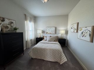 A charming bedroom with a queen-sized bed, dark accent furniture, and elegant wall art. The soft lighting creates a cozy and inviting ambiance.