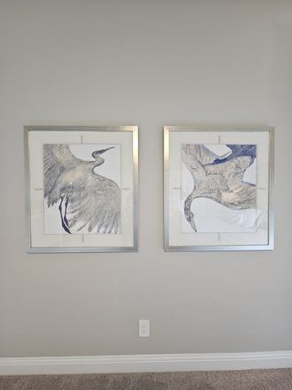 Model Home Elegant wall art featuring two framed bird illustrations with silver frames enhance this neutral-toned room.