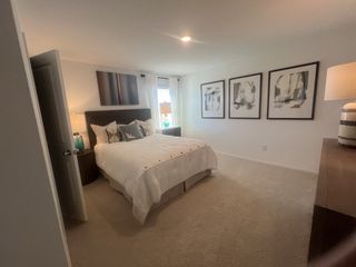 Model Home A cozy primary bedroom with soft lighting, a wooden headboard, and elegant wall.
