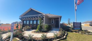 A charming sales center with landscaped gardens in Mesa Vista by Century Communities (Von Ormy, TX).