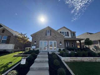 A charming brick home with a manicured yard in the Anthem community by Ashton Woods, Kyle, TX.