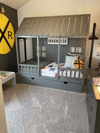 Model Home A cozy children's room featuring a train-themed bed, soft carpet, and playful decor elements.
