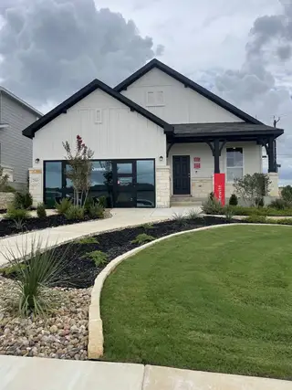 A charming modern home with sleek black accents and lush landscaping in Cinco Lakes by Centex (San Antonio, TX).