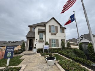 A beautiful two-story model home with elegant landscaping and Texas pride in Veramendi by Highland Homes (New Braunfels, TX).