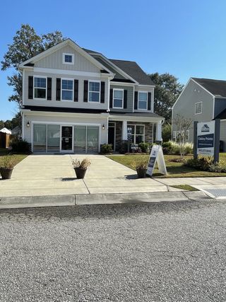 Street view A charming two-story home with a manicured lawn in Oakley Pointe by Eastwood Homes (Moncks Corner, SC).