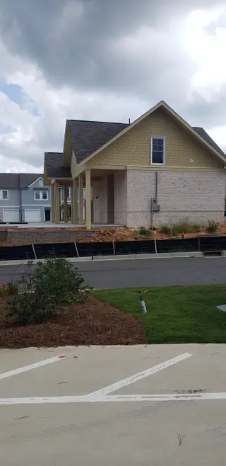 Street view A charming home with a covered porch in The Emery by Starlight Homes, located in Villa Rica, GA.