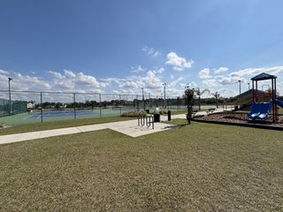 A spacious basketball court with professional markings and scenic surroundings in Avian Pointe Townhomes by D.R. Horton (Apopka, FL).