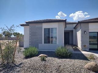 A contemporary home with sleek gray tones and a xeriscaped yard in Stonefield by Homes by Towne (Surprise, AZ).
