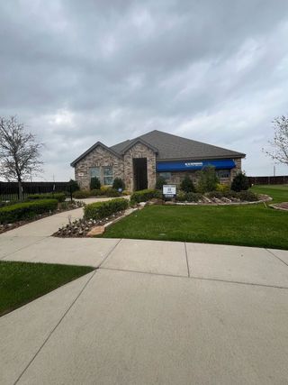 Street view A charming stone-brick home with landscaped yard in Winchester Crossing by D.R. Horton (Princeton, TX).