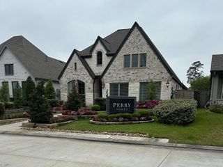 A charming brick home with lush landscaping in Grand Central Park 50' by Perry Homes (Conroe, TX).
