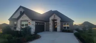 A charming brick and stone home with elegant lighting in Potranco West by LGI Homes (Castroville, TX).
