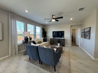 A contemporary living room with plush seating, wooden accents, and bright natural light streaming through large windows.