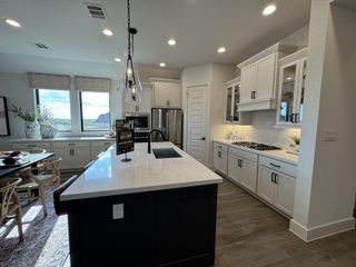 Kitchen: A stunning kitchen with white cabinetry, quartz countertops, and pendant lighting.