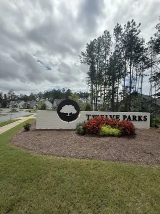 Welcome to Twelve Parks 55+ by Lennar in Sharpsburg, GA, boasting lush greenery and inviting community signage.