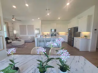 A modern open-concept kitchen and living area with marble accents, stylish decor, and elegant lighting.