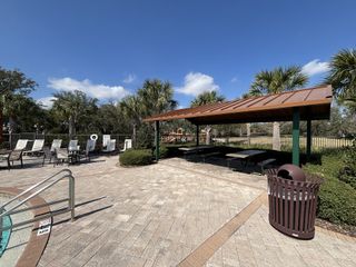 Community Amenities A stylish outdoor poolside pavilion with seating and lush landscaping in Kindred by D.R. Horton (Kissimmee, FL).