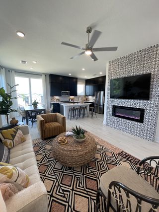 A modern living space with patterned tile fireplace, sleek kitchen, and cozy seating.