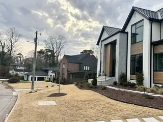 A modern home with sleek design and manicured lawn in North Hills by Homestead Building Company (Raleigh, NC).