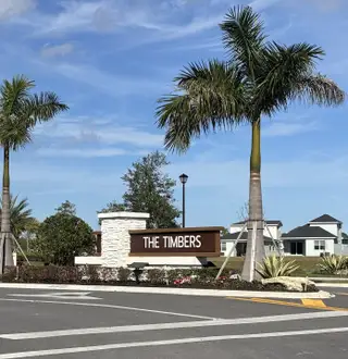 A welcoming entrance with palm trees in The Timbers at Everlands by Lennar (Palm Bay, FL).