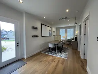 Model Home A cozy office space with large windows, hardwood floors, and modern decor.