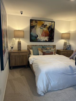 A charming bedroom with warm lighting, wood accents, and artistic decor.