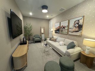 A cozy living room with a plush sofa, chic artwork, and modern decor. Neutral tones create a warm, inviting atmosphere.