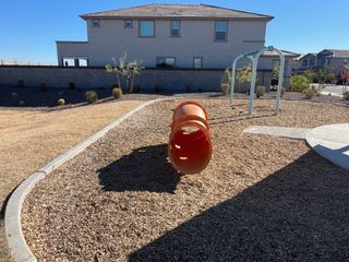 A family-friendly playground with slides and greenery in Mason Ranch ll by D.R. Horton (Surprise, AZ).