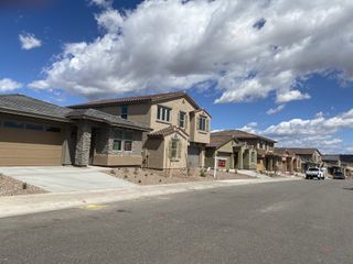 Street view A row of modern homes with varied facades and neutral tones lines a paved street under a bright, partly cloudy sky in Highpointe at Northpointe by Beazer Homes (Peoria, AZ).