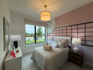 A cozy bedroom with a patterned feature wall, soft lighting, and a large window with a view of the greenery outside.