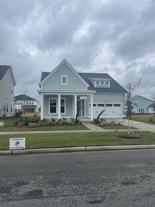 A charming light blue home with a landscaped front yard in Carnes Crossroads by Lennar (Summerville, SC).