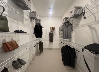 A spacious walk-in closet with organized shelving and ample hanging space for clothes and accessories.