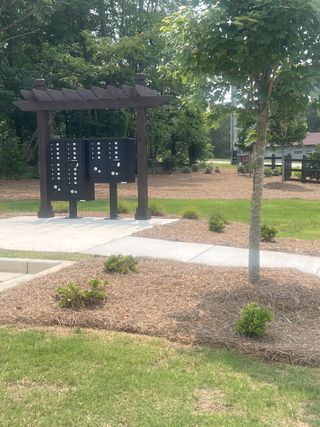 Model Home Community mailboxes with a charming wooden pergola and landscaping in The Overlook at Factory Shoals by Kerley Family Homes (Mableton, GA).