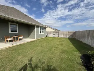 A charming backyard with a cozy patio in Covered Bridge by Ashton Woods, Hutto, TX.