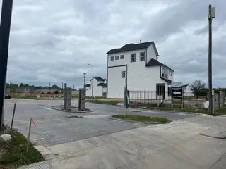 A modern white home with a fenced yard in Regents Court by Colina Homes (Houston, TX).