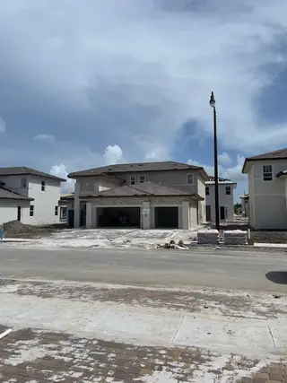 Modern two-story home under construction in Crescent Ridge by Lennar, Davie, FL, featuring spacious garages.