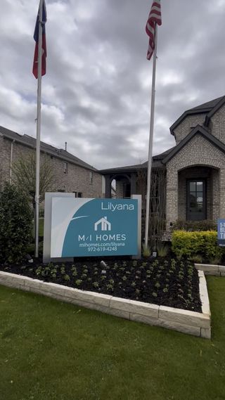A charming brick home entrance with flags, located in Lilyana by M/I Homes (Prosper, TX).