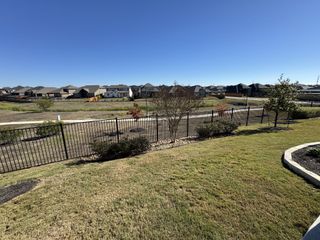 Street view Scenic views of a tranquil neighborhood in Sunfield by Brightland Homes, Buda, TX, with open skies and landscaped areas.