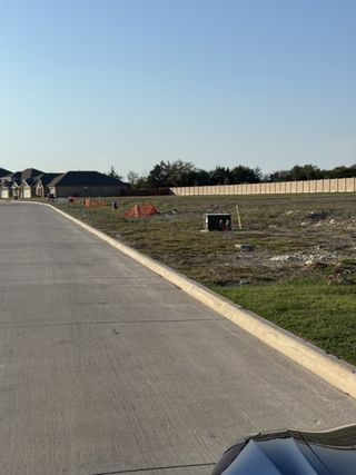 Street view Expansive construction area with new homes in Meadow Park by Ashton Woods, Melissa, TX.