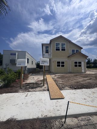 Street view A new two-story home under construction in Baxley Villas by Drees Custom Homes, Middleburg, FL, with a clear blue sky backdrop.
