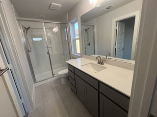 A modern bathroom featuring a sleek vanity, spacious shower, and elegant fixtures with a neutral color palette.