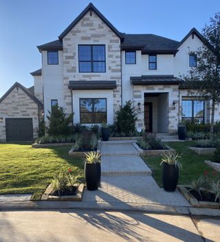 Street view A charming brick home with manicured landscaping in The Woodlands Hills by J. Patrick Homes (Willis, TX).