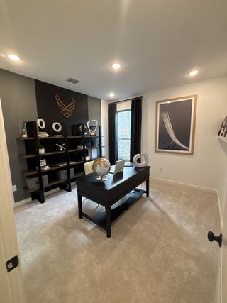 A stylish home office with dark accent walls, modern decor, and natural light in Vista Ridge by HistoryMaker Homes (Live Oak, TX).