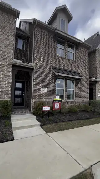 A charming brick townhouse with modern windows and landscaped entry in Plano Gateway by Beazer Homes (Plano, TX).