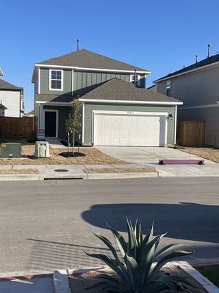 Street view A modern two-story house with a green facade, a two-car garage, and a welcoming front porch. The well-maintained landscaping and surrounding neighborhood contribute to its curb appeal, making it an attractive and contemporary living space.